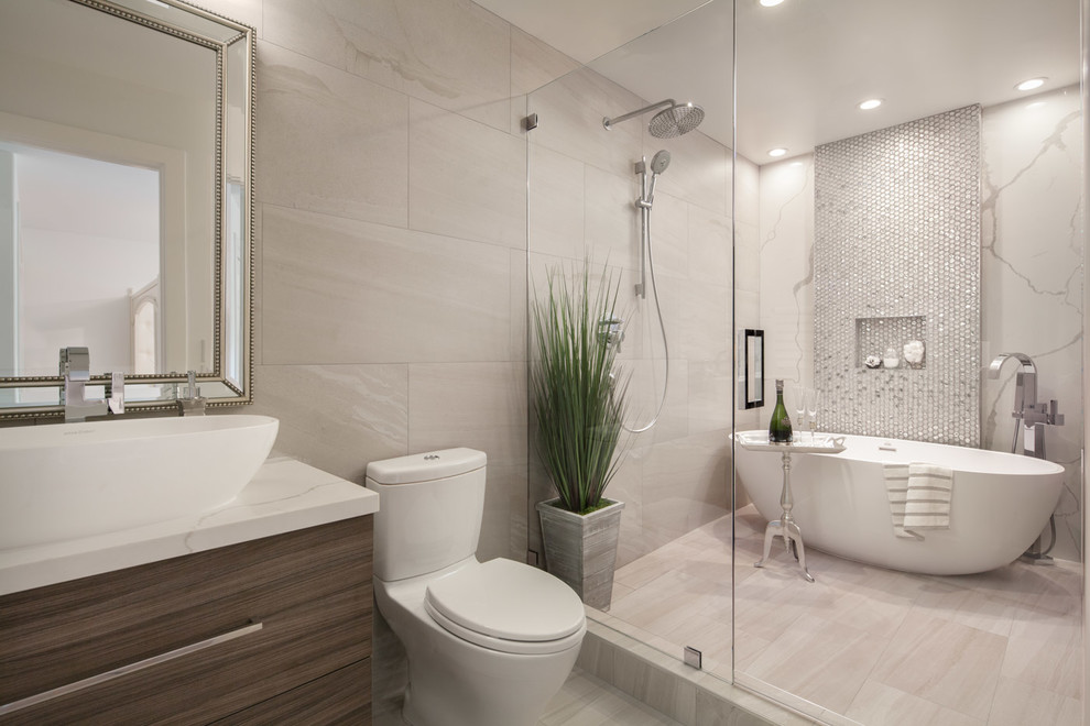 Design ideas for a contemporary master wet room bathroom in San Francisco with flat-panel cabinets, dark wood cabinets, a freestanding tub, a one-piece toilet, beige tile, multi-coloured tile, mosaic tile, beige walls, a vessel sink, beige floor, a hinged shower door and white benchtops.