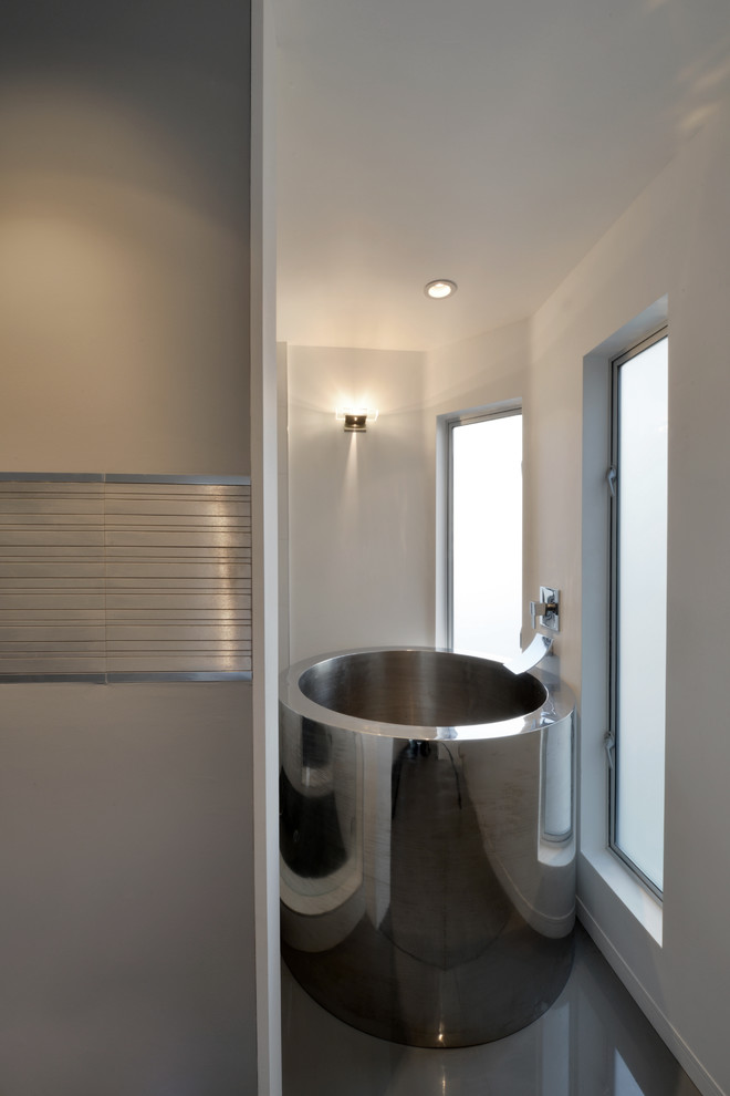 Design ideas for a mid-sized modern master bathroom in Other with flat-panel cabinets, a one-piece toilet, gray tile, stone slab, yellow walls, porcelain floors, a japanese tub, an open shower, a vessel sink and engineered quartz benchtops.