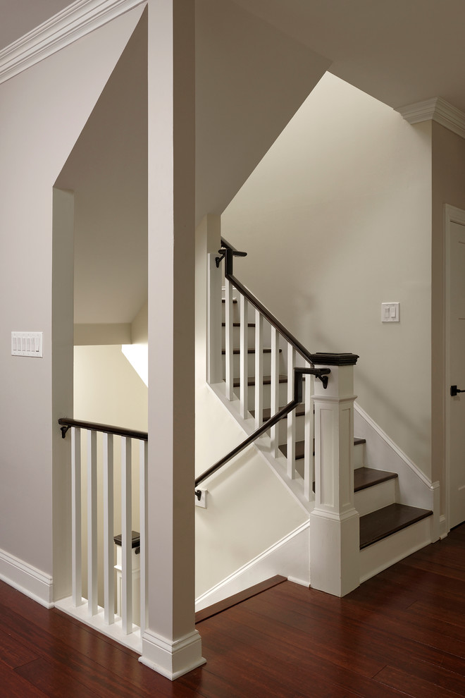 This is an example of a large arts and crafts wood u-shaped staircase in DC Metro with painted wood risers and wood railing.