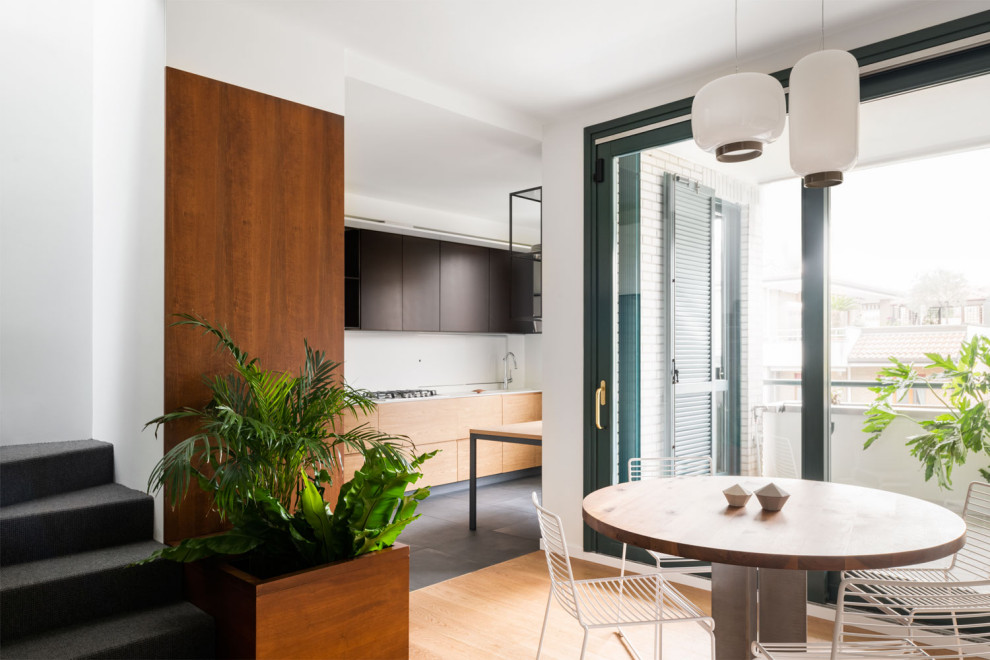 Mid-sized kitchen/dining combo in Milan with white walls, light hardwood floors and wallpaper.