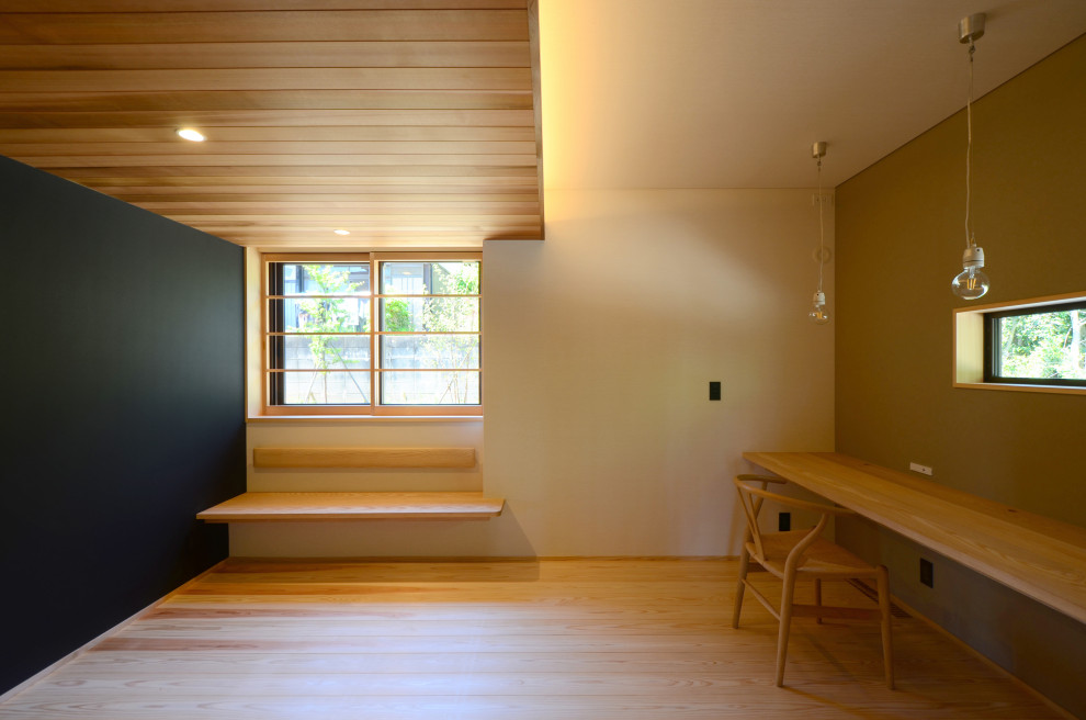 Inspiration för mellanstora arbetsrum, med ett bibliotek, vita väggar, mellanmörkt trägolv, ett inbyggt skrivbord och brunt golv