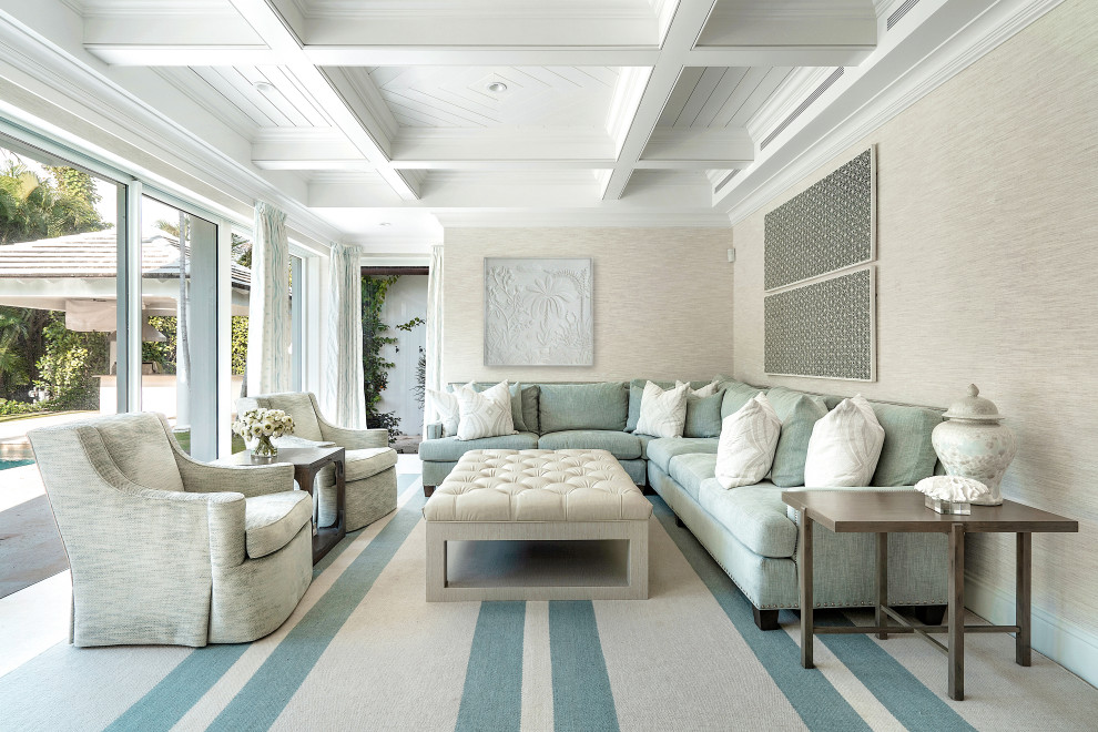 Ejemplo de sala de estar abierta costera extra grande con paredes beige, suelo beige, casetón y papel pintado