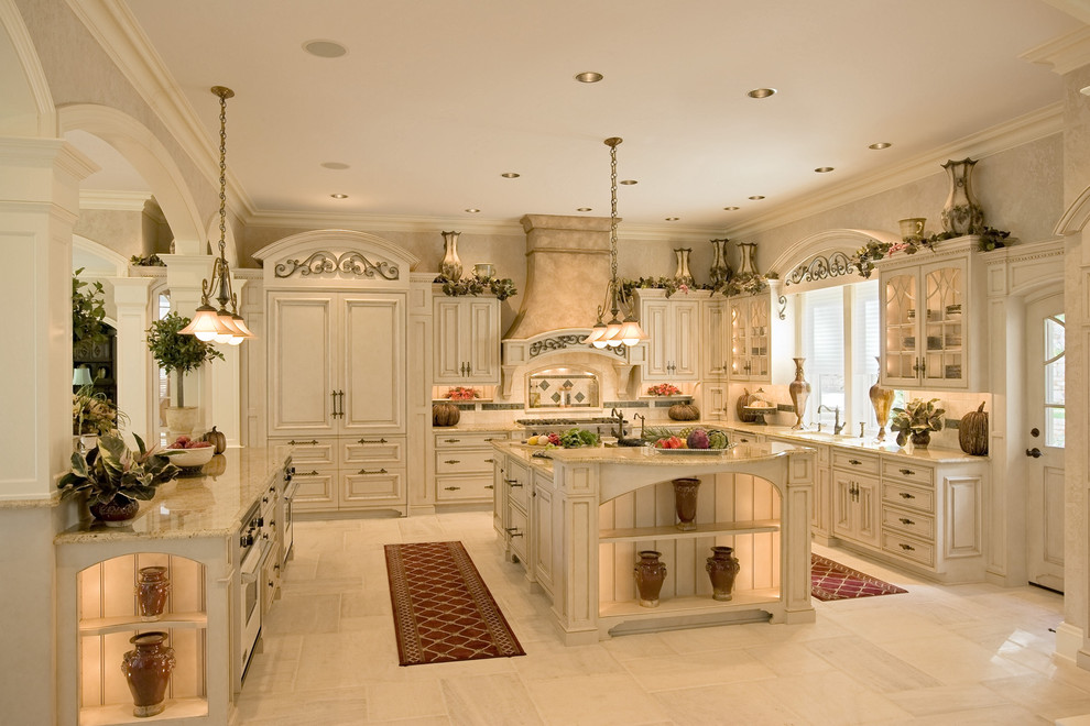 Photo of a large mediterranean l-shaped eat-in kitchen in Philadelphia with an undermount sink, beaded inset cabinets, beige cabinets, granite benchtops, beige splashback, ceramic splashback, panelled appliances, porcelain floors, with island and white floor.