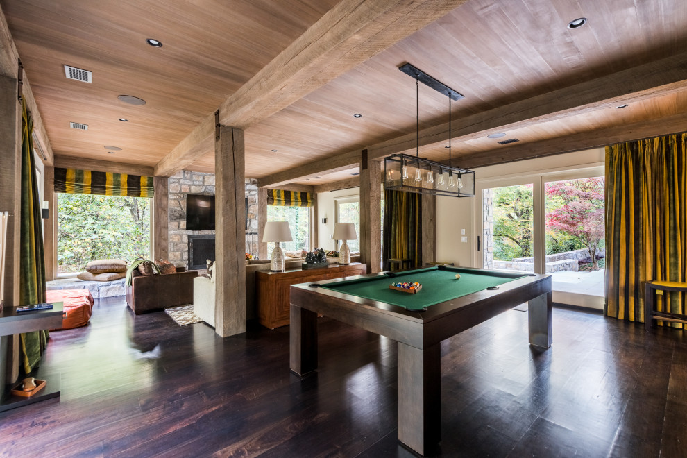 Huge 1950s open concept dark wood floor, brown floor, exposed beam and wood wall game room photo in Atlanta with a standard fireplace, a stone fireplace and a wall-mounted tv