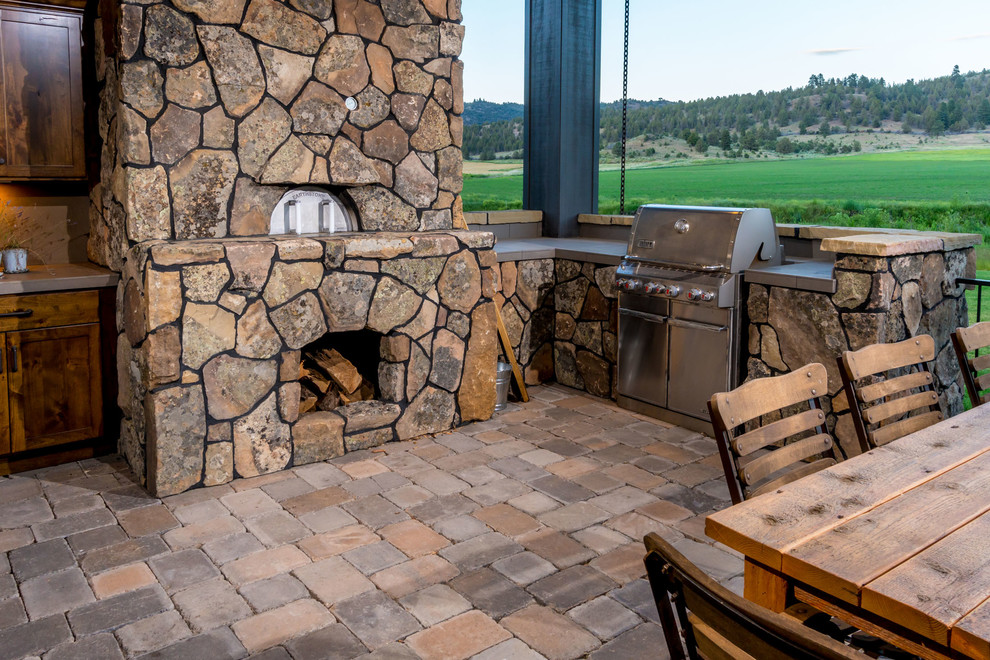 Large mediterranean backyard patio in Other with an outdoor kitchen and brick pavers.
