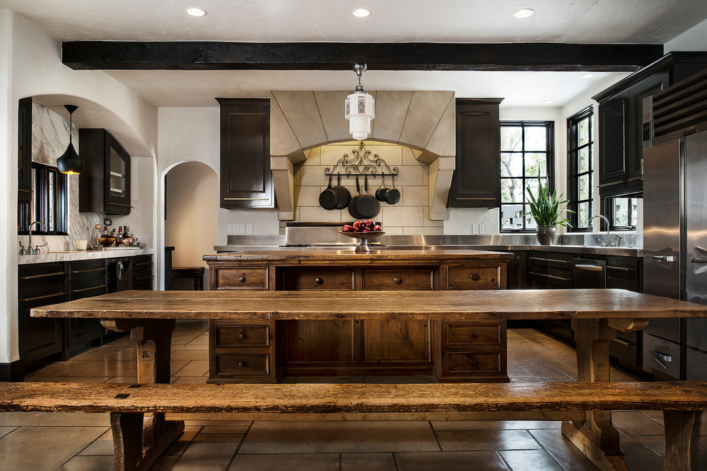 Inspiration for a large rustic u-shaped kitchen remodel with dark wood cabinets, stainless steel appliances and an island