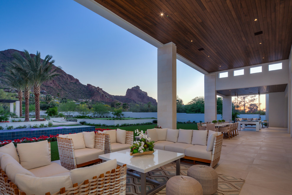 This is an example of an expansive contemporary backyard patio in Phoenix with a roof extension.