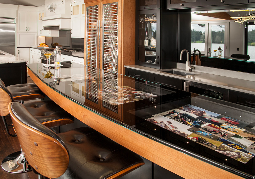 This is an example of a mid-sized contemporary u-shaped seated home bar in Seattle with an undermount sink, glass-front cabinets, black cabinets, glass benchtops, mirror splashback and dark hardwood floors.