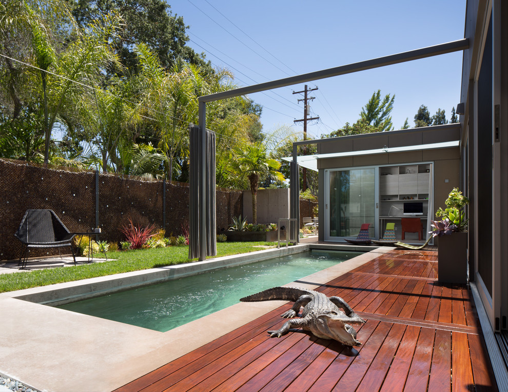 This is an example of a mid-sized contemporary backyard rectangular infinity pool in San Francisco with decking.