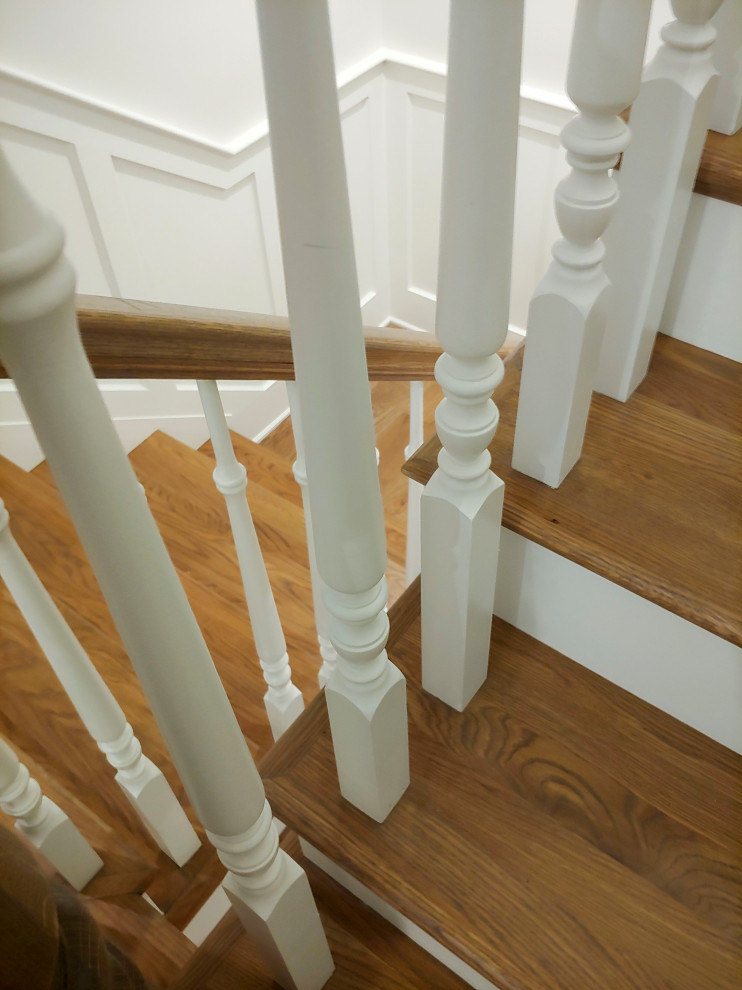 Example of a mid-sized classic wooden u-shaped wood railing and wainscoting staircase design in DC Metro with painted risers