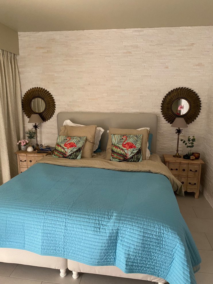 Diseño de dormitorio mediterráneo de tamaño medio con paredes blancas, suelo de baldosas de cerámica, suelo blanco y ladrillo
