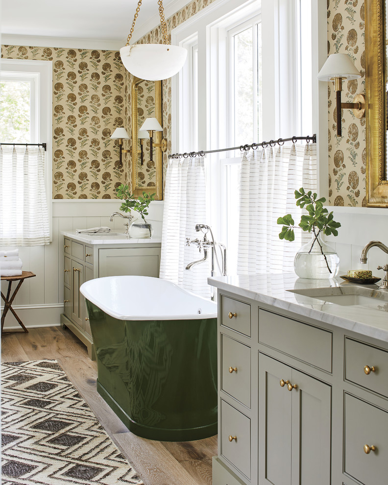 Design ideas for a beach style master bathroom in Jacksonville with beaded inset cabinets, grey cabinets, a freestanding tub, multi-coloured walls, an undermount sink and white benchtops.