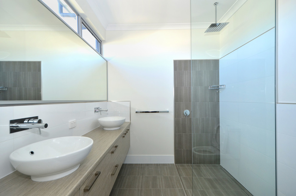 Design ideas for a contemporary bathroom in Perth with a vessel sink, beige cabinets, laminate benchtops, a freestanding tub, ceramic tile, white walls and ceramic floors.