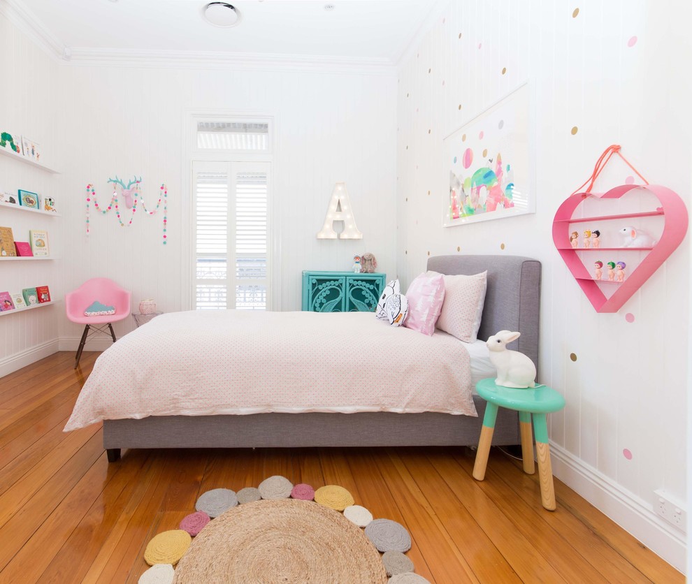 This is an example of a mid-sized contemporary kids' bedroom for girls in Brisbane with white walls and medium hardwood floors.