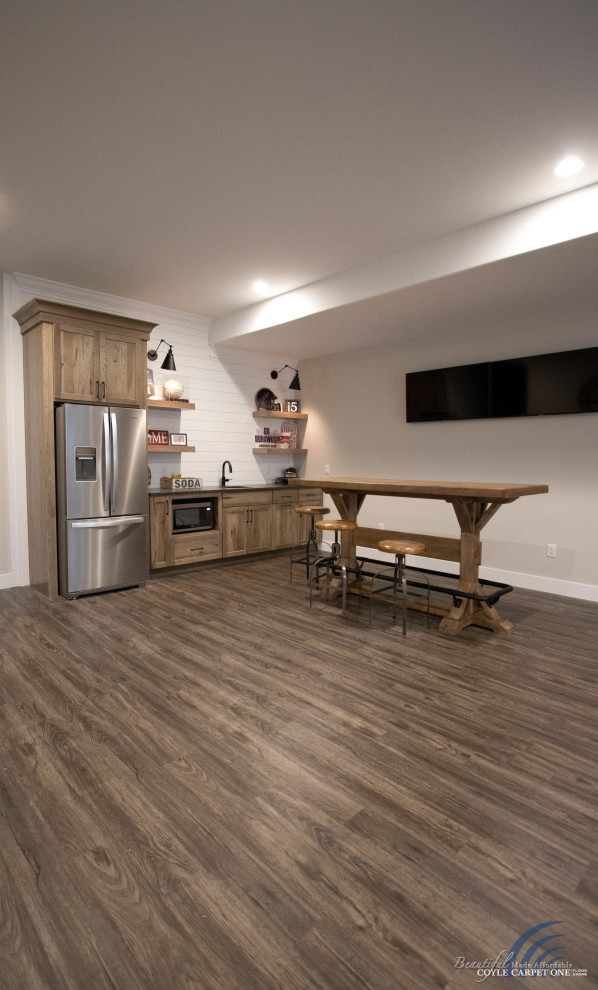 Large transitional vinyl floor and brown floor basement photo with beige walls