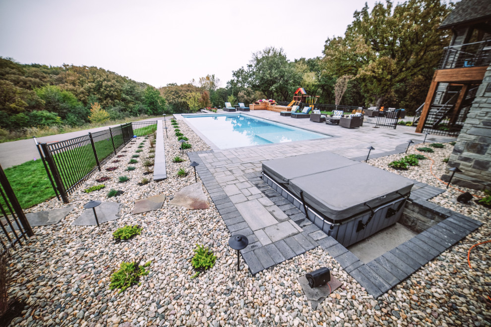 Example of a large transitional backyard concrete paver and rectangular hot tub design