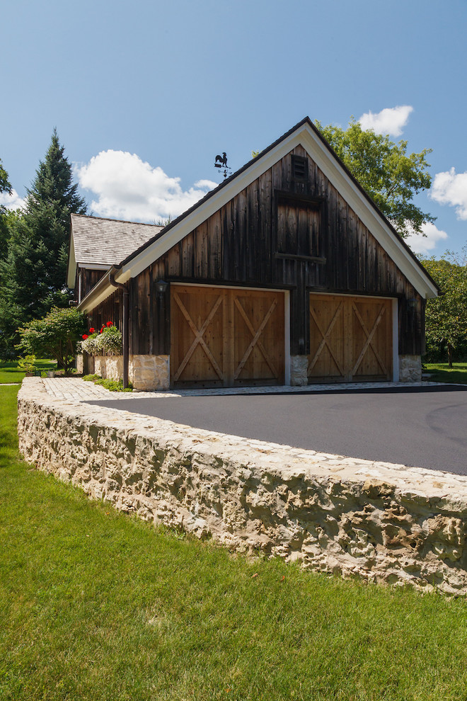 Design ideas for a mid-sized country side yard full sun driveway for summer in Milwaukee with natural stone pavers and a retaining wall.