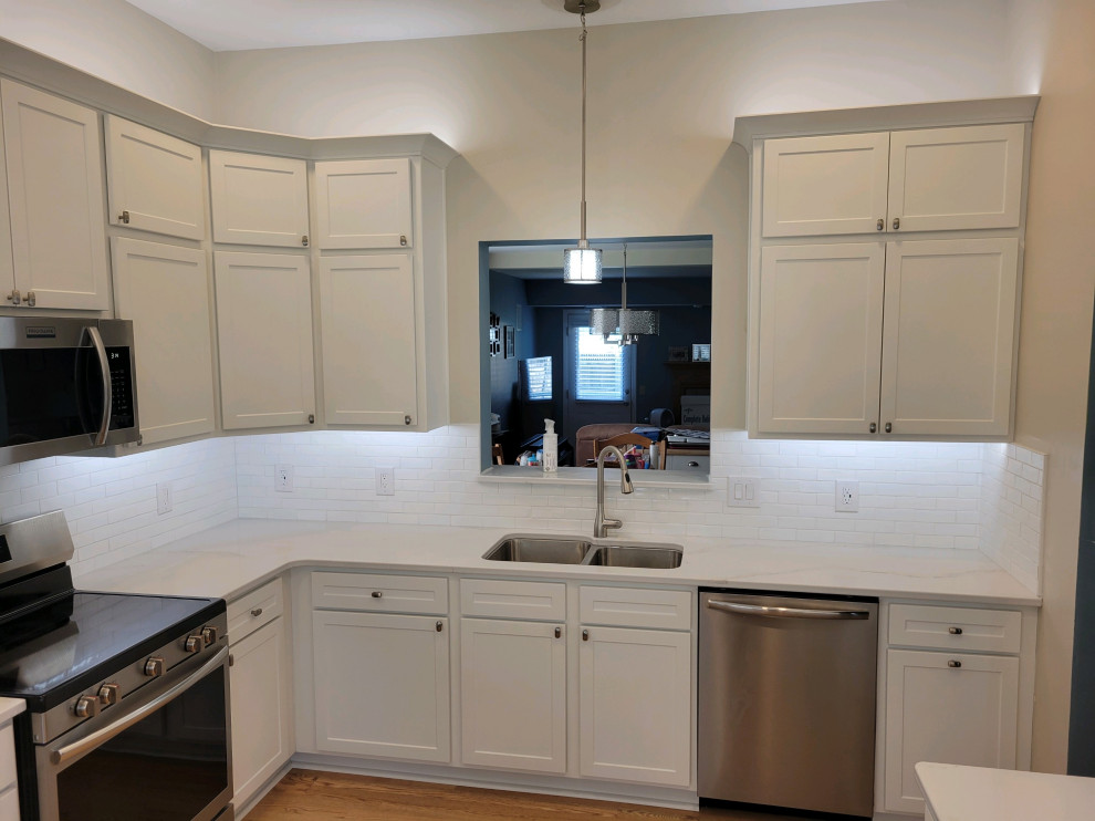 Example of a mid-sized transitional enclosed kitchen design with shaker cabinets, white cabinets, quartz countertops, white backsplash, subway tile backsplash and white countertops