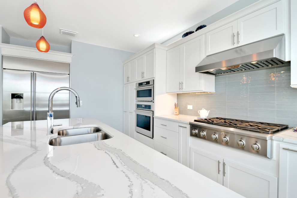 Mid-sized transitional u-shaped porcelain tile and gray floor open concept kitchen photo in Tampa with a double-bowl sink, recessed-panel cabinets, white cabinets, marble countertops, gray backsplash, cement tile backsplash, stainless steel appliances and an island