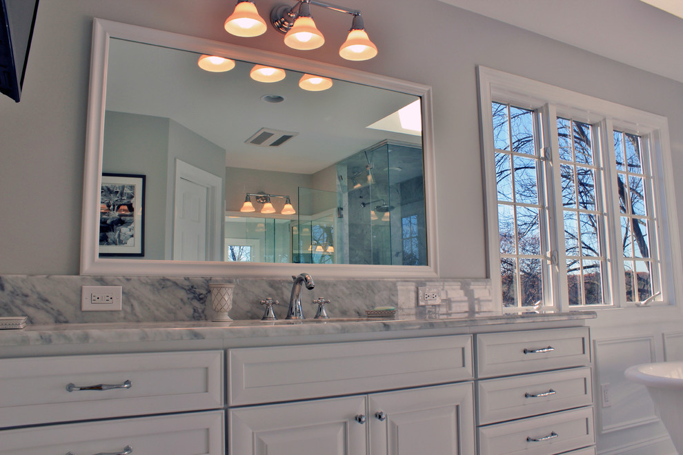 Inspiration for a large traditional master bathroom in Philadelphia with recessed-panel cabinets, white cabinets, a freestanding tub, a corner shower, a two-piece toilet, white tile, grey walls, marble floors, an undermount sink and marble benchtops.