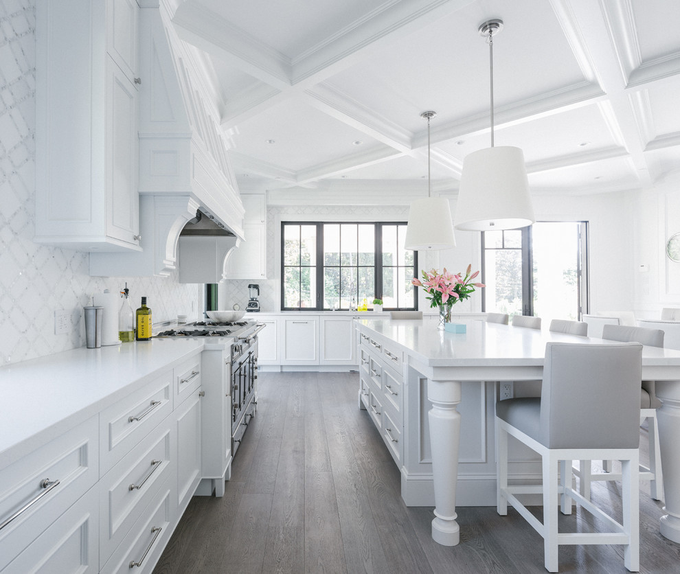 Photo of a large traditional l-shaped kitchen in Vancouver with with island, white cabinets, white splashback, beaded inset cabinets and light hardwood floors.