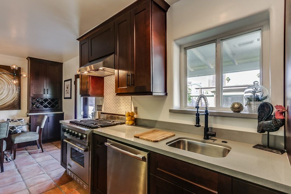 Example of a large transitional galley terra-cotta tile and brown floor open concept kitchen design in Phoenix with an undermount sink, shaker cabinets, dark wood cabinets, quartz countertops, stainless steel appliances and an island