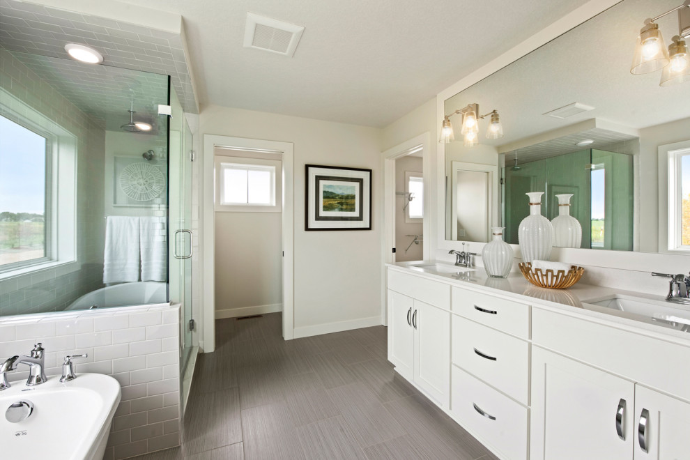 Design ideas for a transitional master bathroom in Minneapolis with shaker cabinets, white cabinets, a freestanding tub, a corner shower, a one-piece toilet, gray tile, subway tile, grey walls, ceramic floors, an undermount sink, quartzite benchtops, grey floor, a hinged shower door and white benchtops.