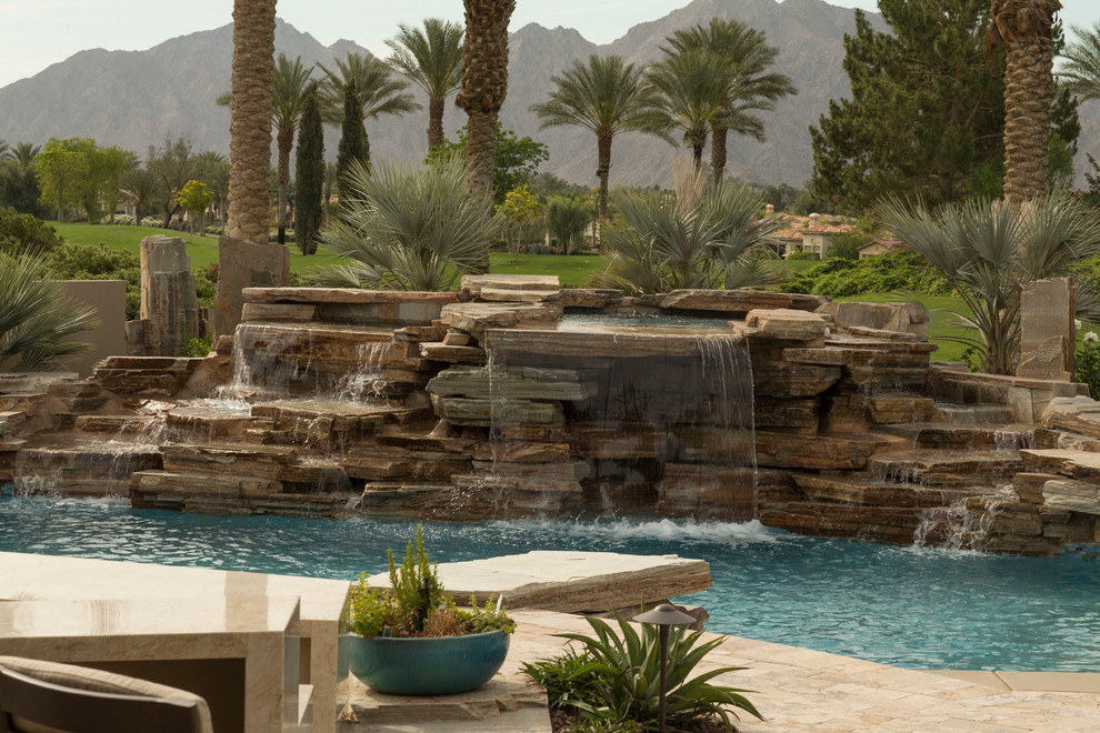 Mid-sized transitional backyard concrete paver and round natural pool fountain photo