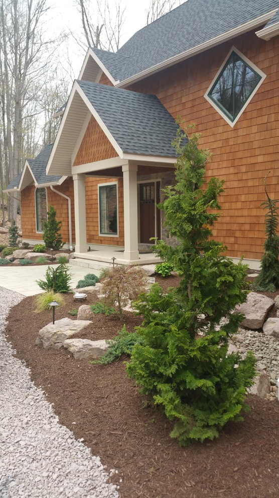 Country front yard garden in Other with natural stone pavers.
