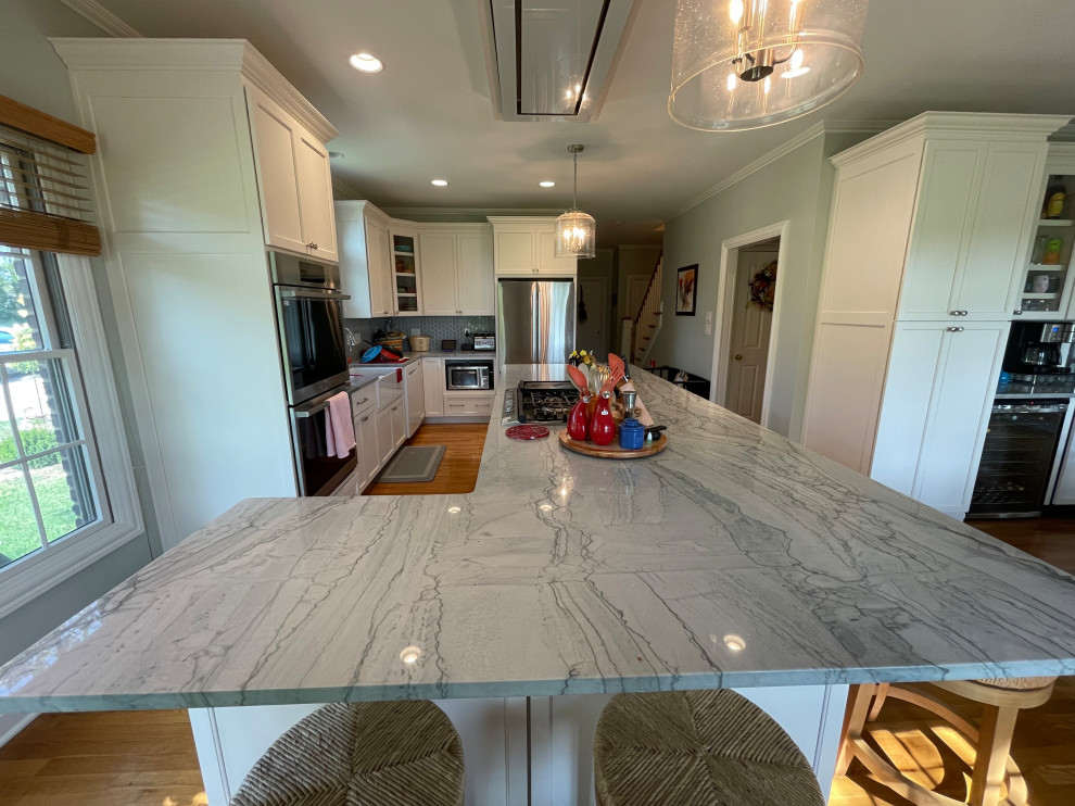 Eat-in kitchen - large transitional light wood floor and brown floor eat-in kitchen idea with an undermount sink, shaker cabinets, white cabinets, quartzite countertops, green backsplash, marble backsplash, stainless steel appliances, an island and gray countertops