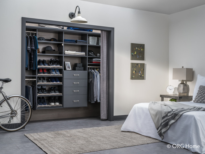 Design ideas for a mid-sized contemporary gender-neutral walk-in wardrobe in Burlington with flat-panel cabinets, grey cabinets, concrete floors and grey floor.