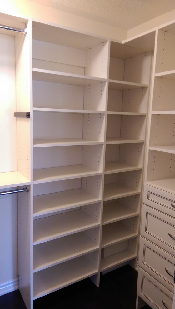 Photo of a mid-sized modern women's built-in wardrobe in Toronto with dark hardwood floors, white cabinets and open cabinets.