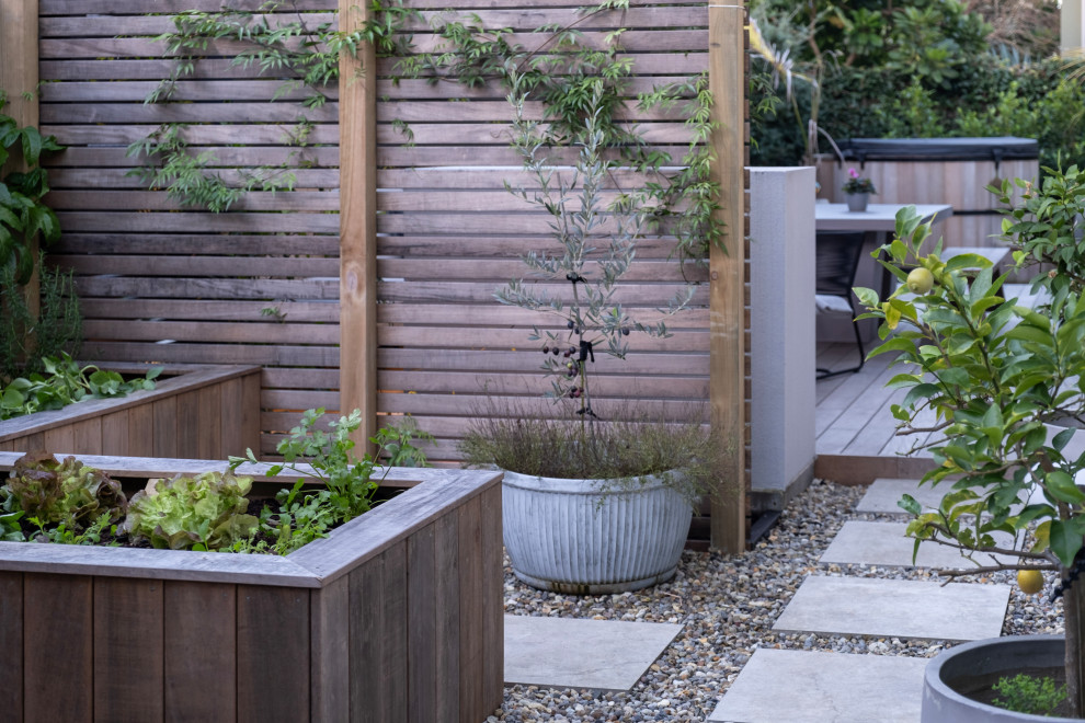 Inspiration for a contemporary side yard full sun garden in Auckland with a vegetable garden, river rock and a wood fence.