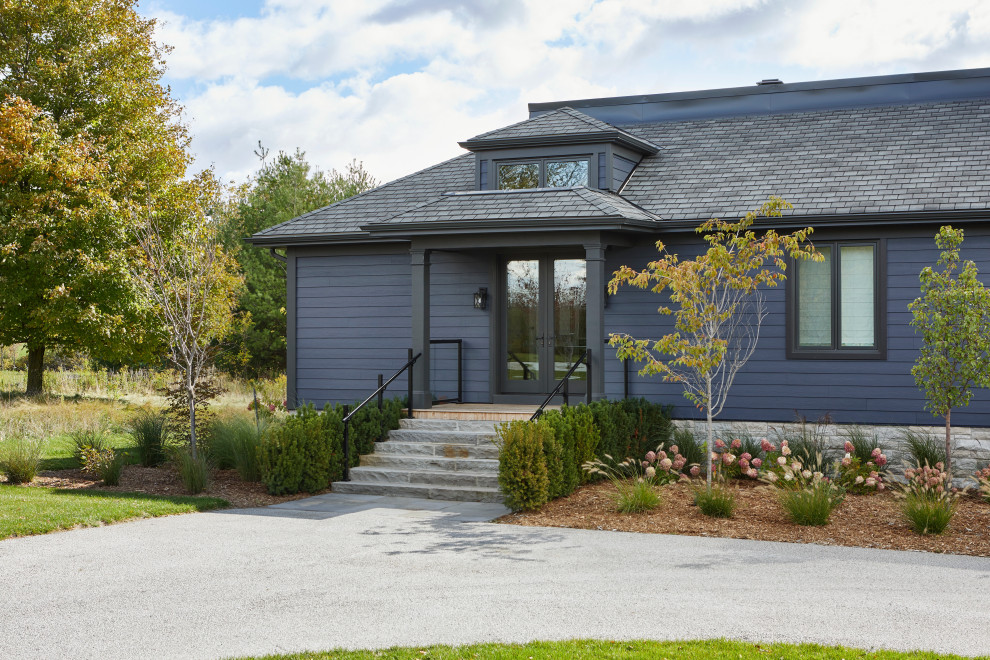 Large transitional blue split-level clapboard and wood house exterior photo in Toronto with a gambrel roof, a shingle roof and a black roof