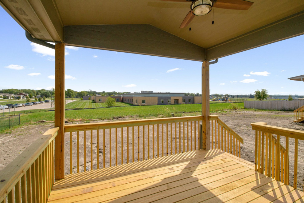 Example of a mid-sized transitional backyard deck design with a roof extension