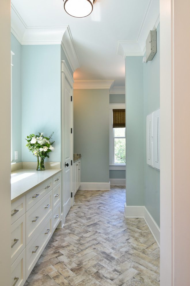 This is an example of a mid-sized transitional l-shaped utility room in Charleston with an undermount sink, shaker cabinets, beige cabinets, quartz benchtops, blue walls, porcelain floors, a side-by-side washer and dryer, multi-coloured floor and beige benchtop.