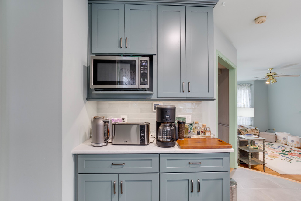 ワシントンD.C.にある広いトランジショナルスタイルのおしゃれなキッチン (落し込みパネル扉のキャビネット、青いキャビネット、クオーツストーンカウンター、セメントタイルのキッチンパネル、シルバーの調理設備、アイランドなし) の写真