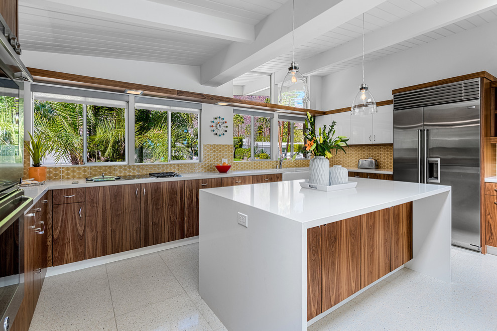Design ideas for a mid-sized midcentury u-shaped eat-in kitchen in Other with a farmhouse sink, flat-panel cabinets, medium wood cabinets, quartzite benchtops, yellow splashback, ceramic splashback, stainless steel appliances and with island.