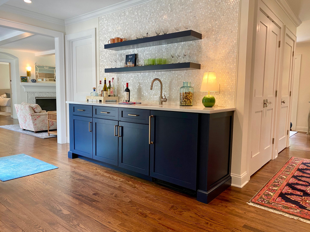Large contemporary single-wall wet bar in Los Angeles with an undermount sink, shaker cabinets, blue cabinets, quartz benchtops, white splashback, glass sheet splashback, medium hardwood floors, brown floor and white benchtop.
