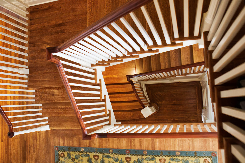 Photo of an expansive traditional wood u-shaped staircase in New York with wood risers and wood railing.