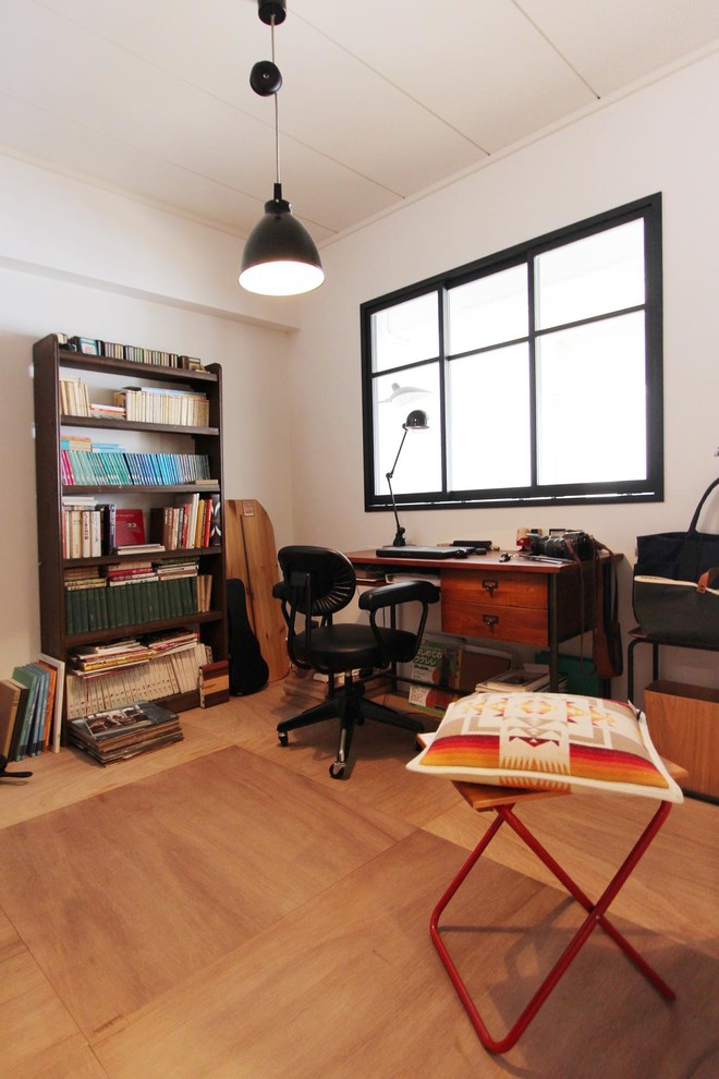 Design ideas for a mid-sized scandinavian home office in Tokyo with white walls, medium hardwood floors, no fireplace, a freestanding desk and brown floor.