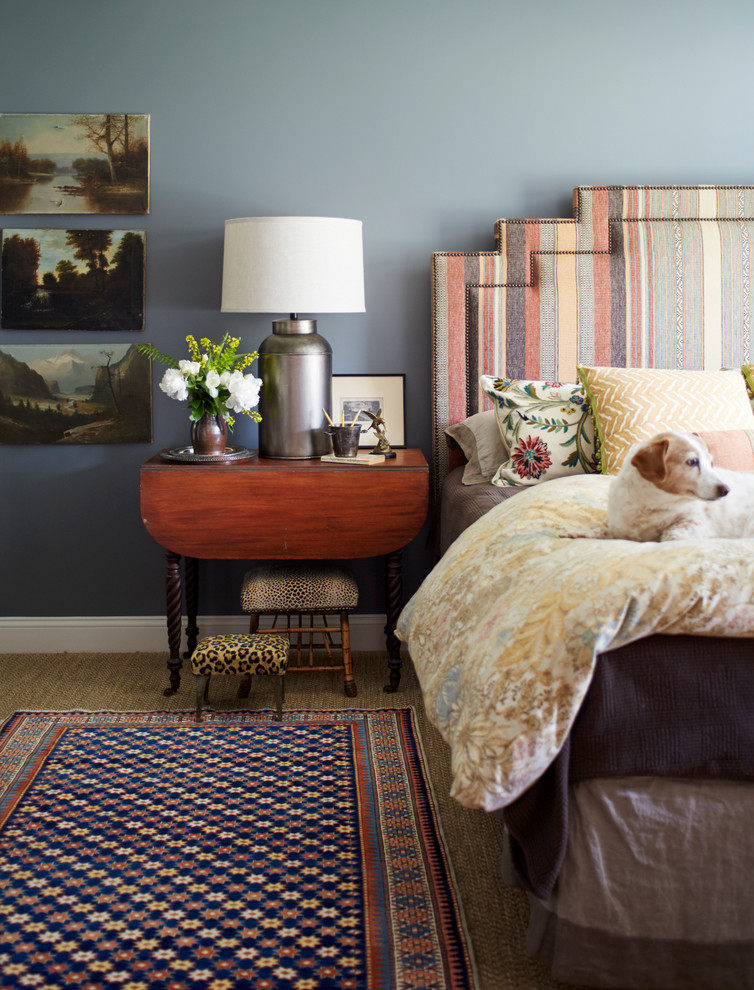This is an example of a country bedroom in New York with blue walls, carpet and brown floor.