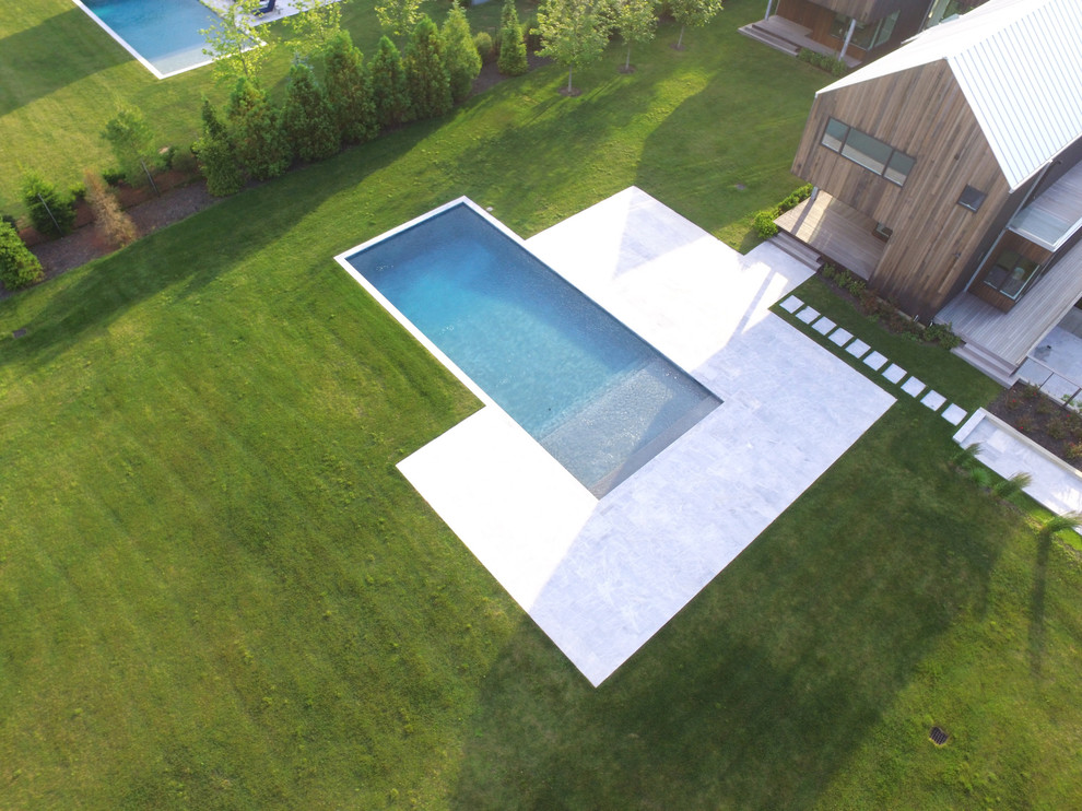 Pool - large backyard stone and rectangular aboveground pool idea in New York