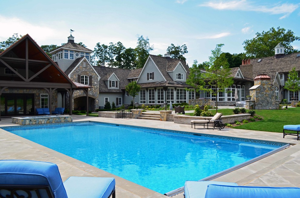 Photo of a large traditional backyard rectangular lap pool in New York with a hot tub.