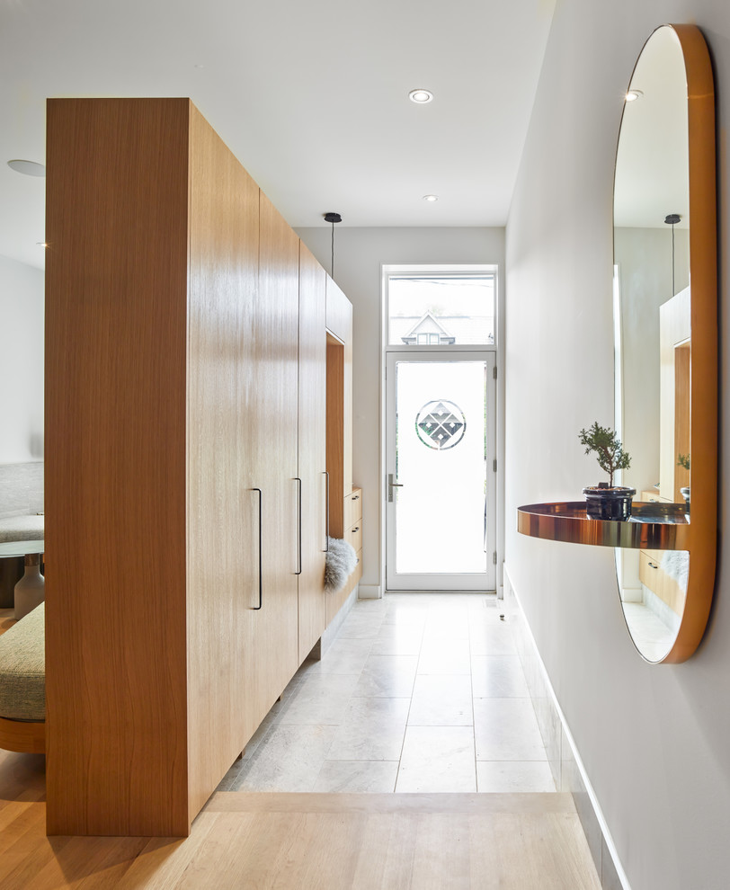 Photo of a mid-sized scandinavian entry hall in Toronto with grey walls, marble floors, a single front door, a glass front door and grey floor.