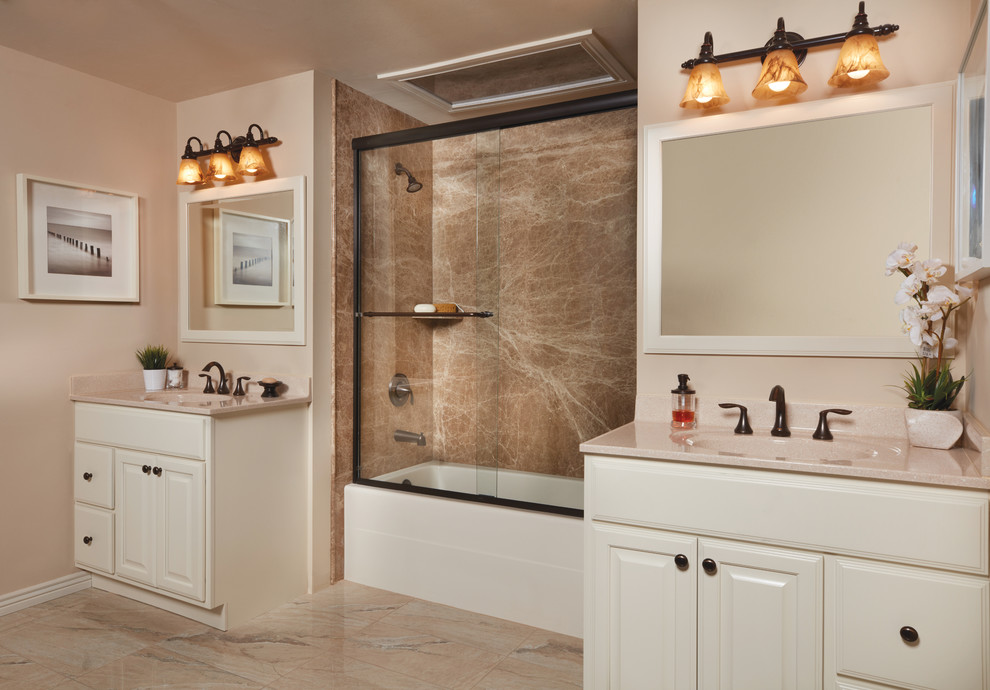 This is an example of a mid-sized traditional master bathroom in New Orleans with raised-panel cabinets, beige cabinets, an alcove tub, a shower/bathtub combo, brown tile, stone slab, beige walls, ceramic floors, an integrated sink, beige floor, a sliding shower screen and beige benchtops.