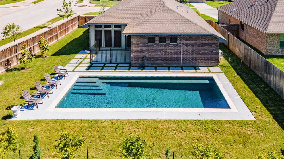 Foto de piscina alargada clásica pequeña rectangular en patio trasero con losas de hormigón