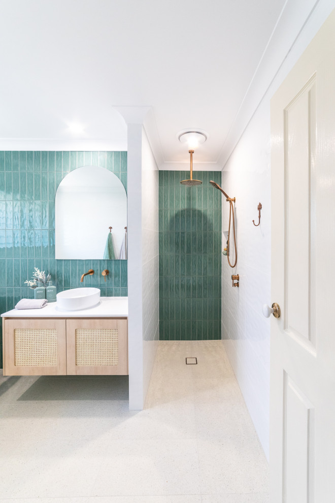 Photo of a mid-sized beach style master bathroom in Newcastle - Maitland with light wood cabinets, a freestanding tub, an open shower, multi-coloured tile, ceramic tile, white walls, porcelain floors, a vessel sink, solid surface benchtops, white floor, an open shower, white benchtops, a niche, a single vanity and a floating vanity.