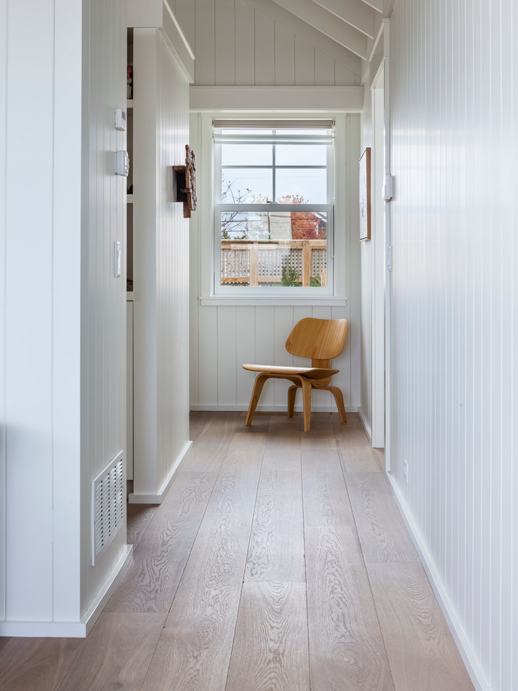 Design ideas for a beach style hallway in Boston with white walls and medium hardwood floors.