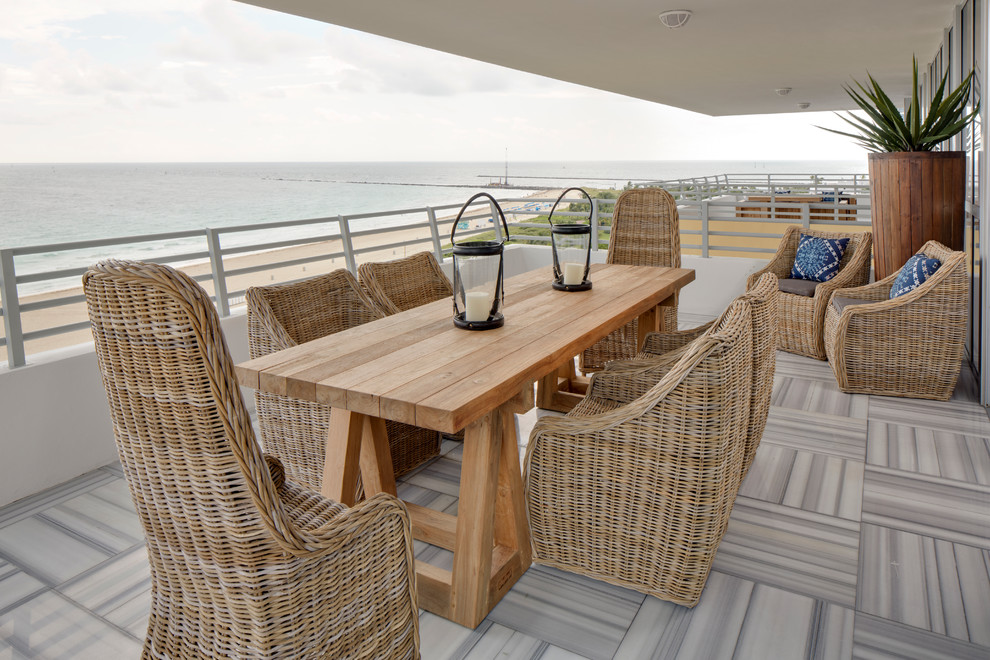 This is an example of a mid-sized beach style balcony in Miami with a roof extension.